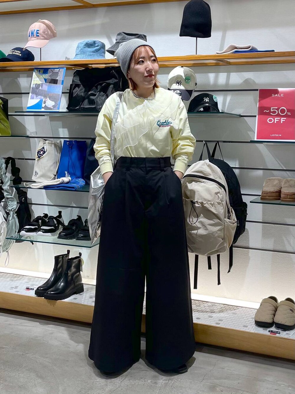 シルバー系のトートバッグ、ブラック系のチノパンツ、イエロー系のTシャツ/カットソーを着用したレディースの春コーディネートの2枚目の写真