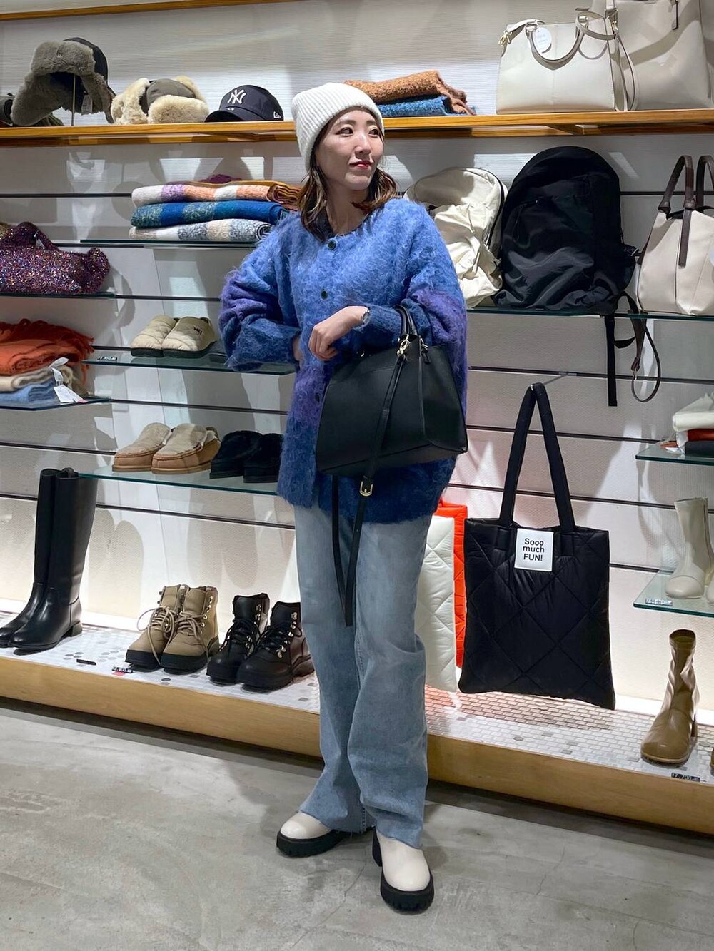 ブルー系のデニムパンツ、ホワイト系のブーツ、ブルー系のカーディガン/ボレロを着用したレディースの冬コーディネートの2枚目の写真