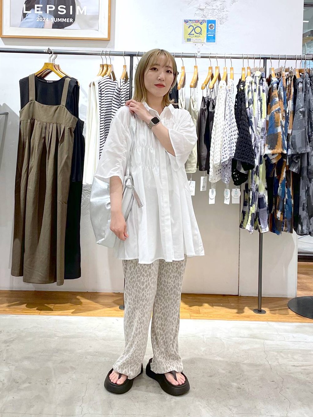 ブラック系のサンダル、シルバー系のトートバッグ、ホワイト系のシャツ/ブラウスを着用したレディースの夏コーディネートの2枚目の写真