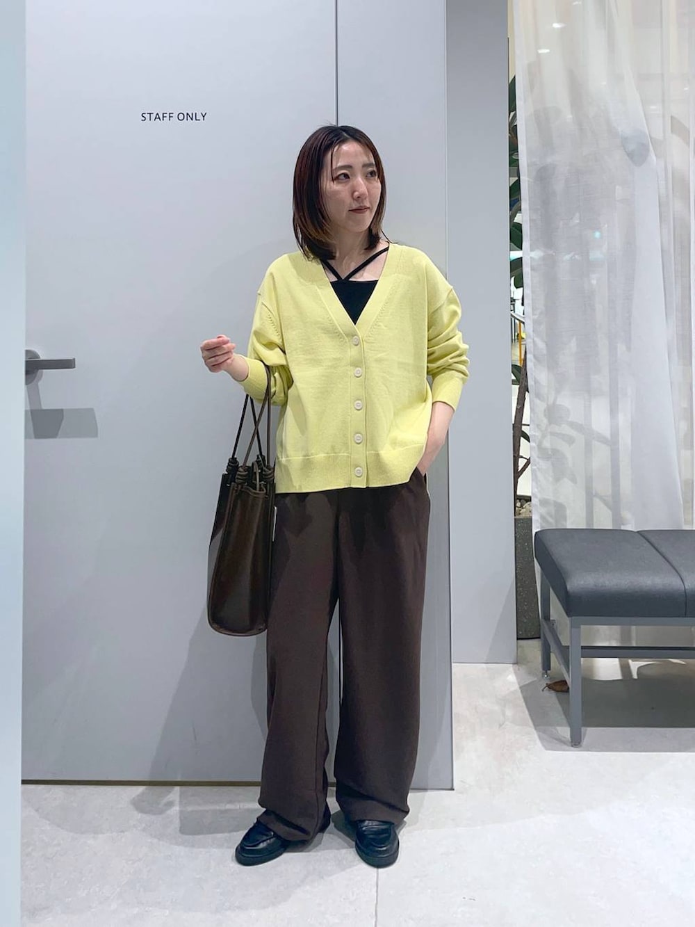 イエロー系のカーディガン/ボレロ、ブラウン系のその他パンツ、ブラウン系のトートバッグを着用したレディースの春コーディネートの2枚目の写真