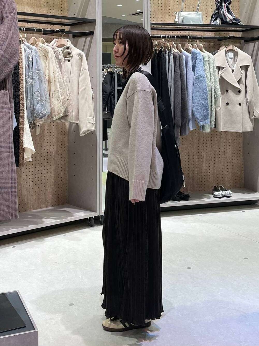 ブラック系のショルダーバッグ、ベージュ系のワンピースを着用したレディースの冬コーディネートの4枚目の写真