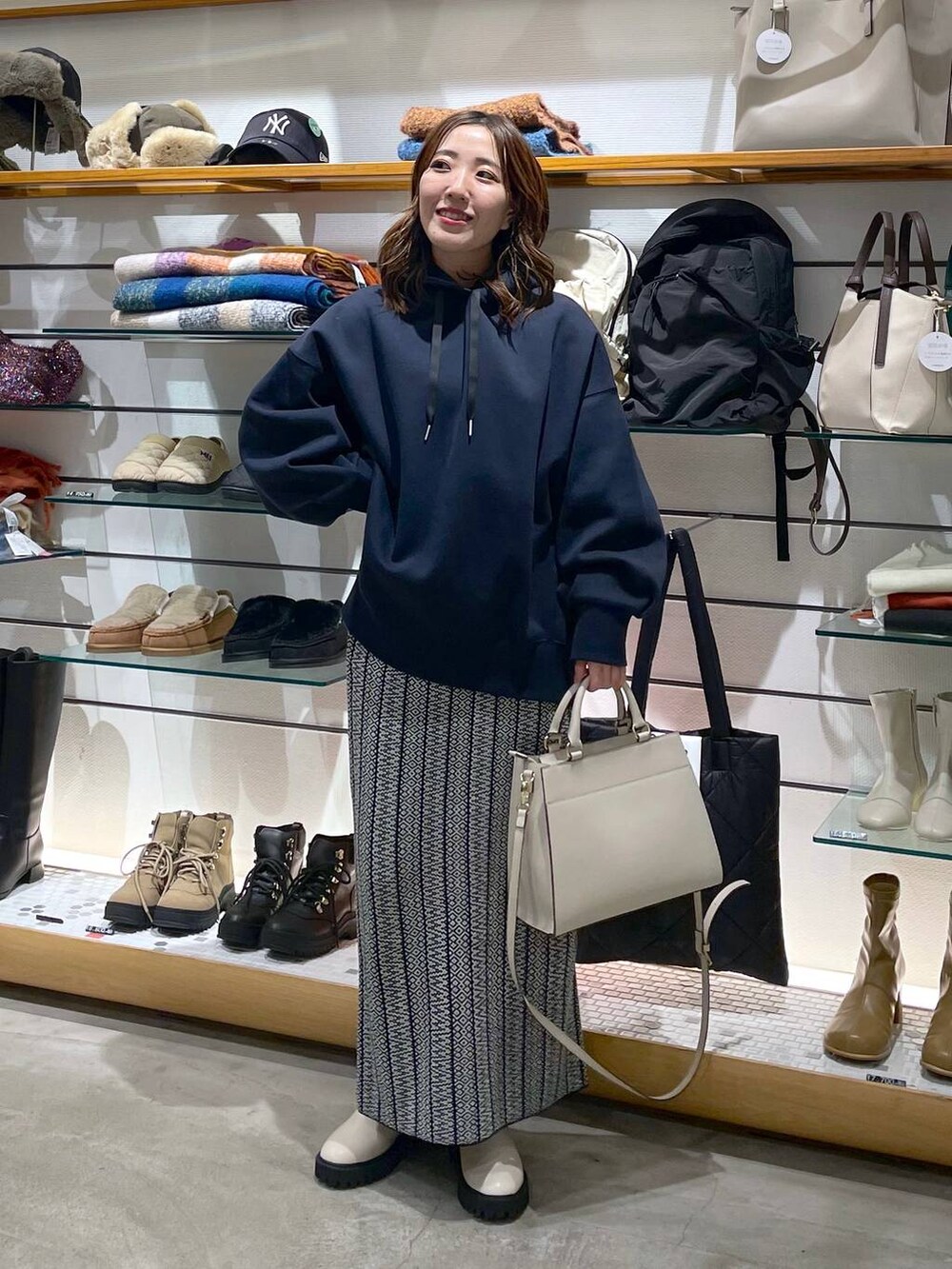 ホワイト系のブーツ、ブラック系のスカート、ブルー系のパーカーを着用したレディースの冬コーディネートの2枚目の写真