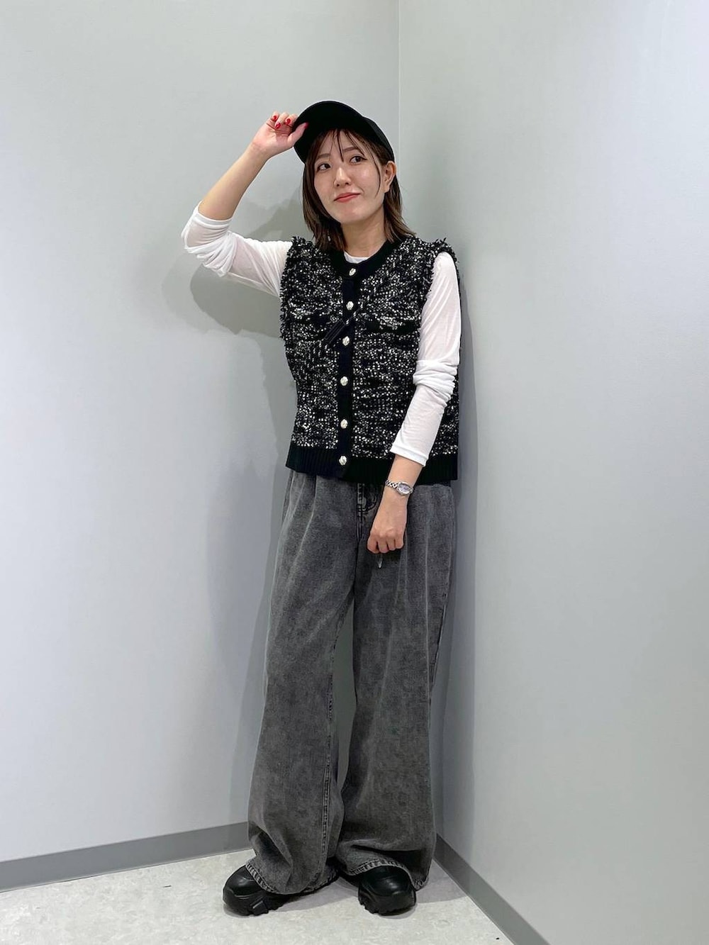 ブラック系のベスト、ホワイト系のTシャツ/カットソー、グレー系のデニムパンツを着用したレディースの秋コーディネートの2枚目の写真