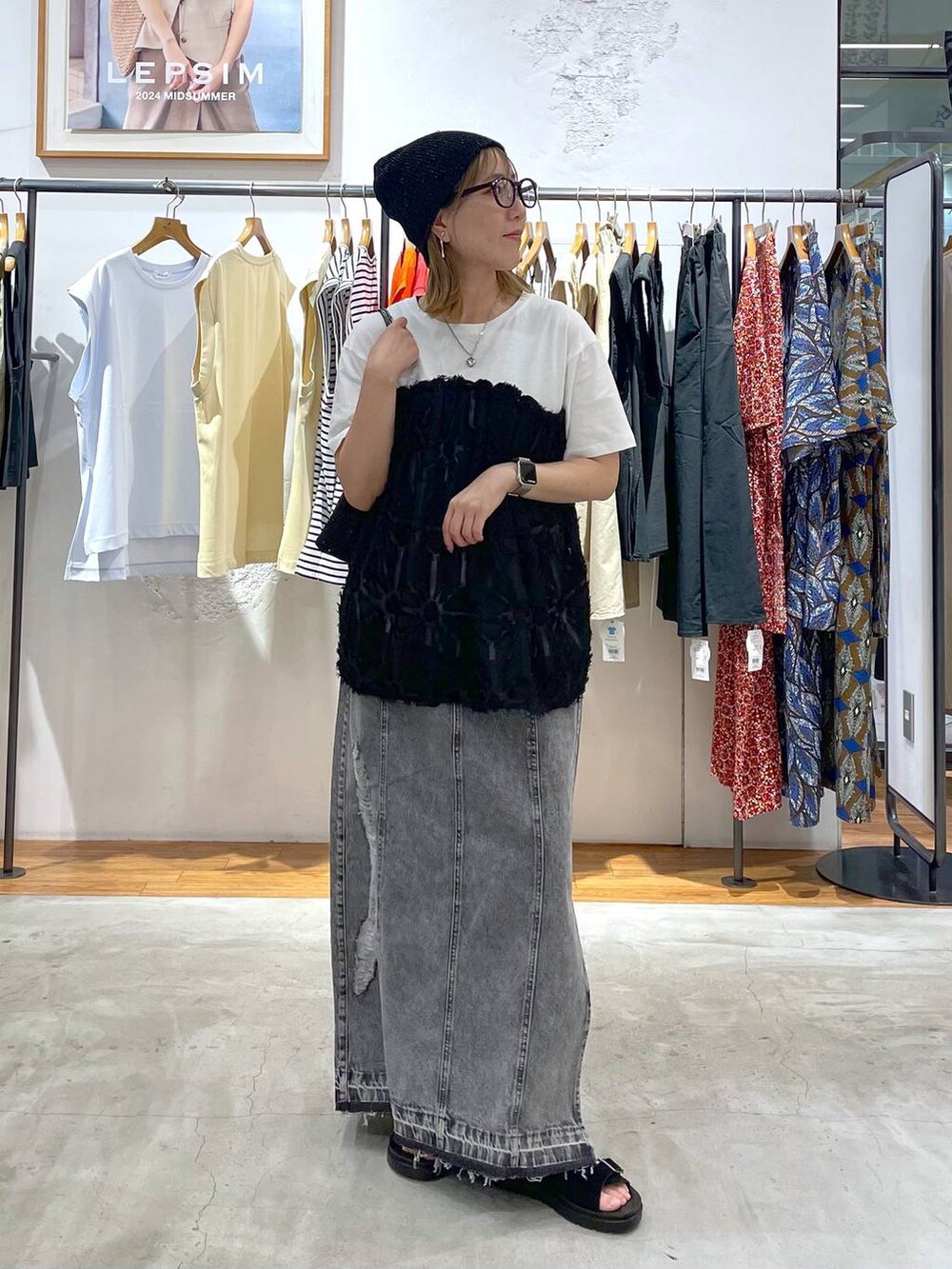 ブラック系のショルダーバッグ、ホワイト系のTシャツ/カットソー、ブラック系のサンダルを着用したレディースの夏コーディネートの3枚目の写真