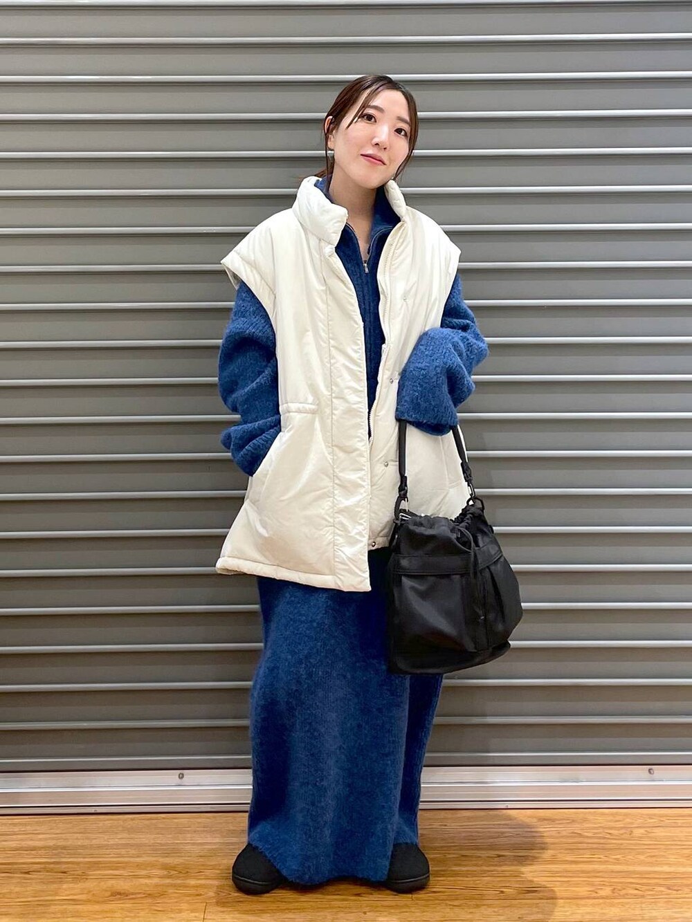 ホワイト系のその他アウター、ブラック系のその他シューズ、ブラック系のショルダーバッグを着用したレディースの冬コーディネートの2枚目の写真