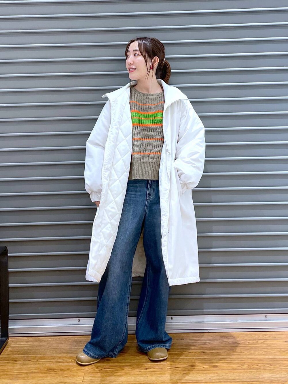 ブルー系のデニムパンツ、ブラウン系のブーツ、ベージュ系のニット/セーターを着用したレディースの秋コーディネートの3枚目の写真