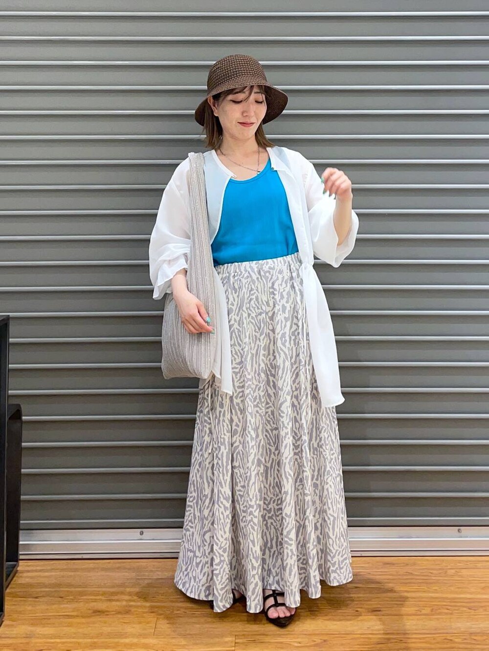 ブラック系のサンダル、ホワイト系のスカート、ホワイト系のシャツ/ブラウスを着用したレディースの春コーディネートの2枚目の写真