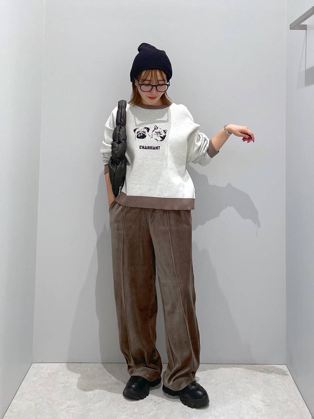 ブラウン系のその他パンツ、ブラック系のハンドバッグ、ベージュ系のニット/セーターを着用したレディースの秋コーディネートの2枚目の写真