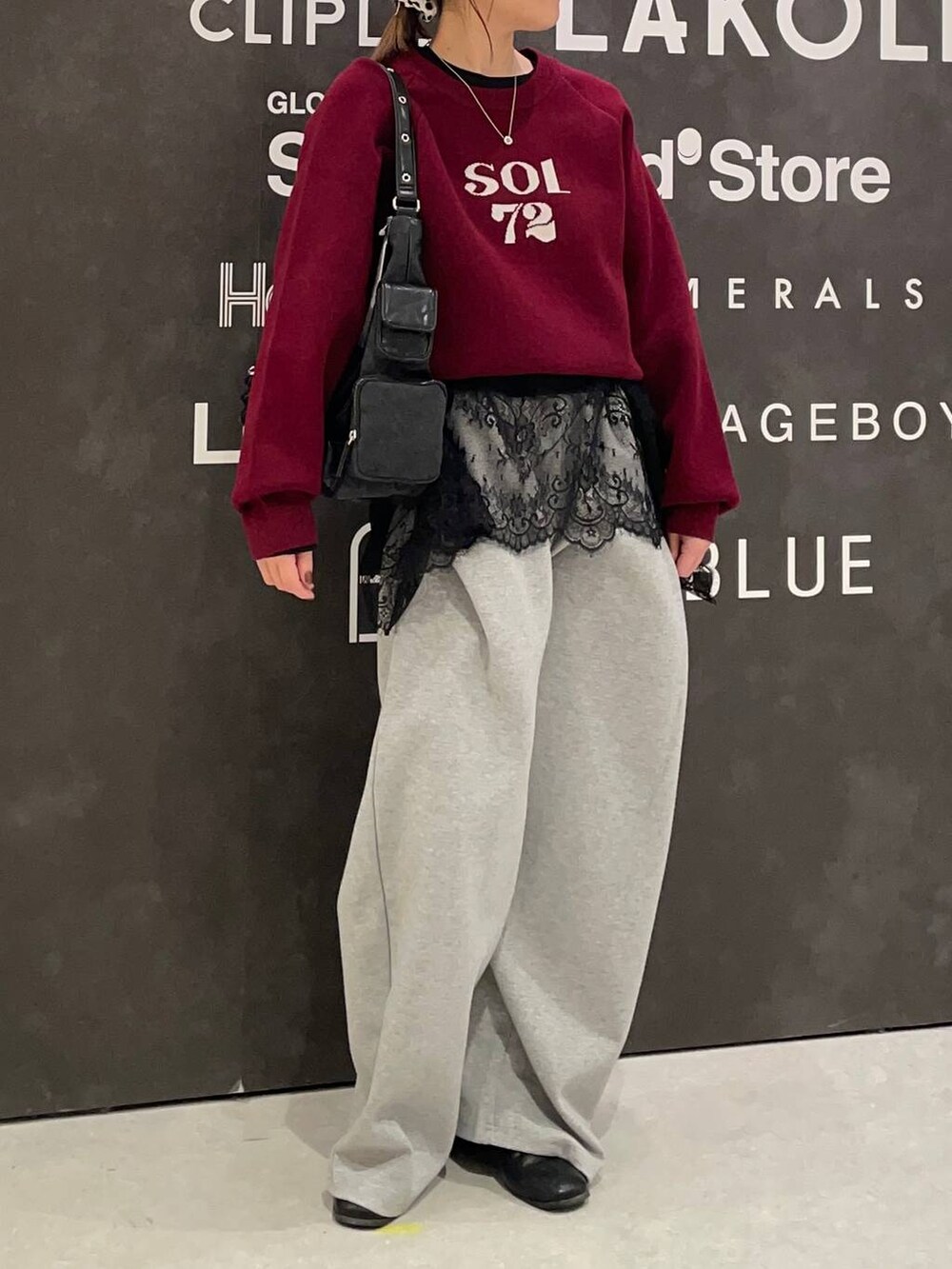 ブラック系のショルダーバッグ、ホワイト系のTシャツ/カットソー、レッド系のニット/セーターを着用したレディースの冬コーディネートの2枚目の写真