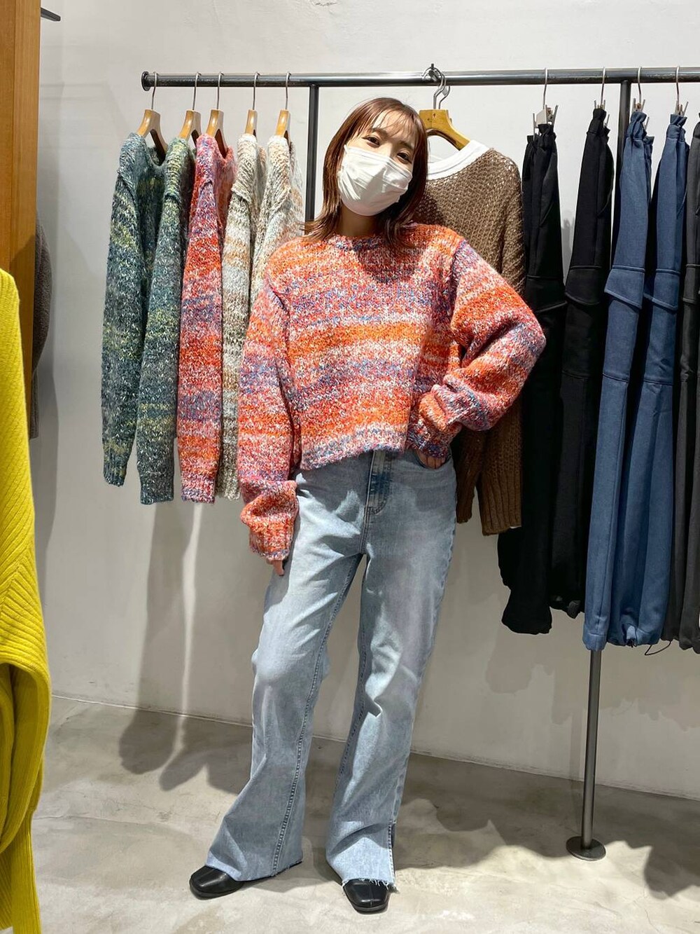 ブルー系のデニムパンツ、レッド系のニット/セーターを着用したレディースの冬コーディネートの3枚目の写真