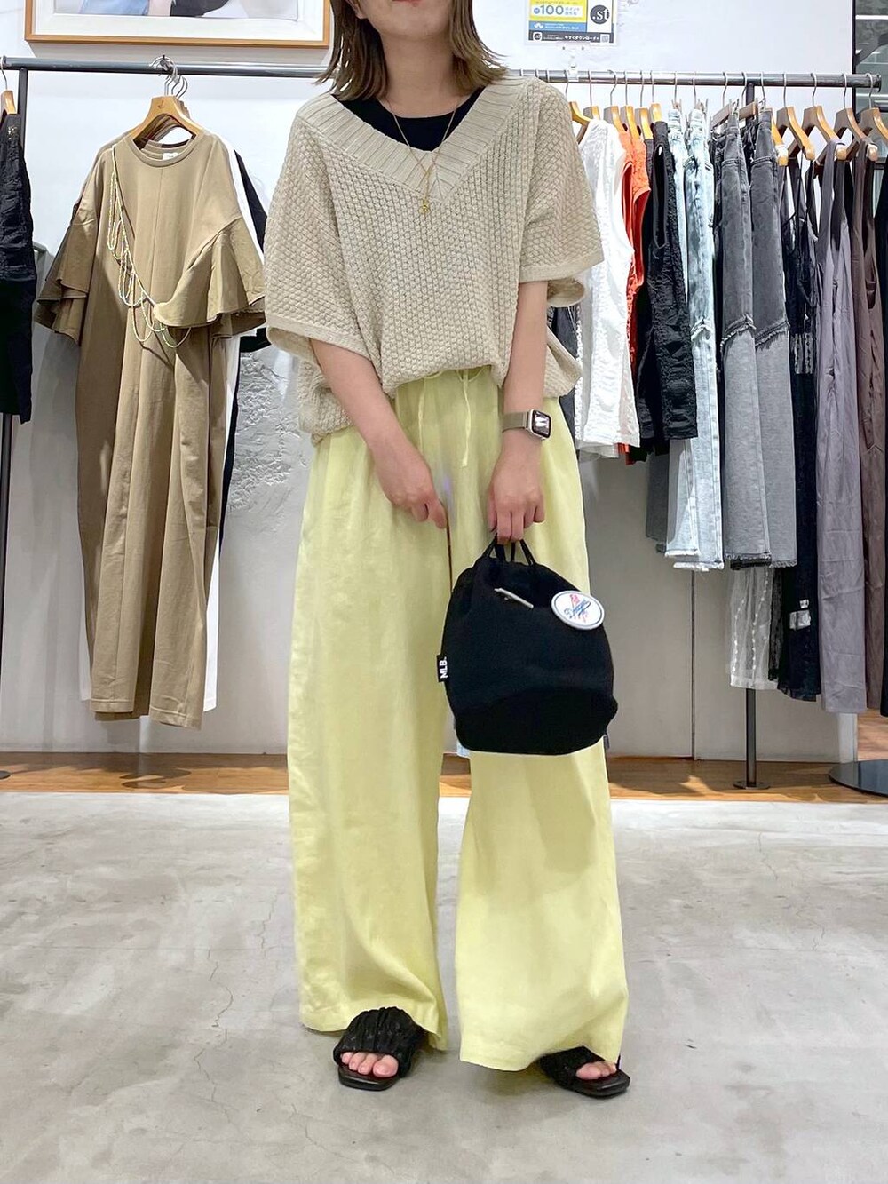 ブラック系のタンクトップ、イエロー系のその他パンツ、ブラック系のショルダーバッグを着用したレディースの夏コーディネートの3枚目の写真