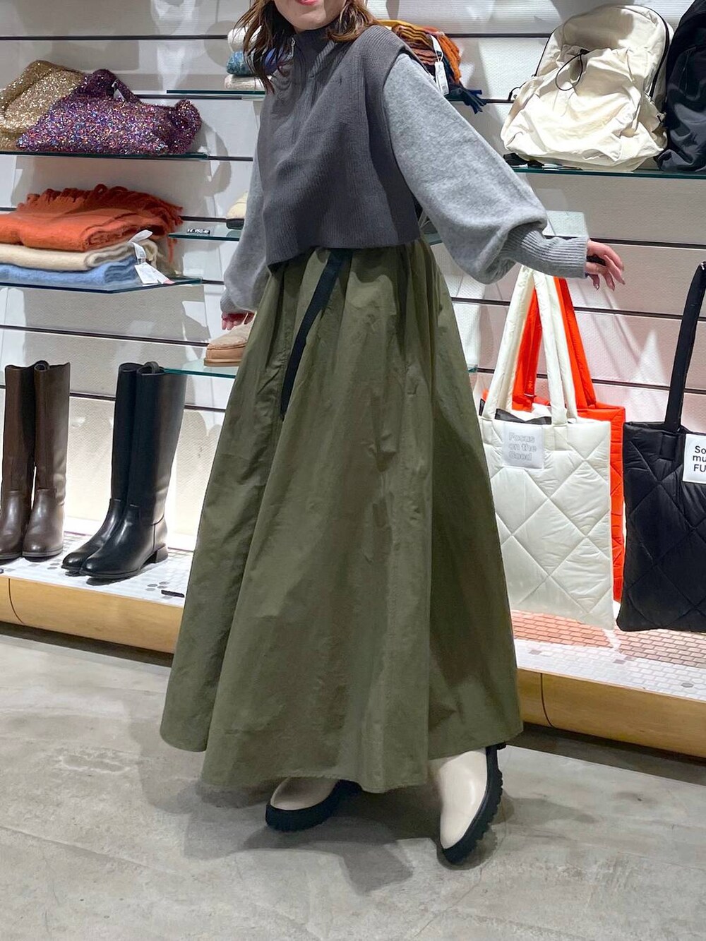 グレー系のニット/セーター、ホワイト系のブーツ、グレー系のニット/セーターを着用したレディースの冬コーディネートの2枚目の写真