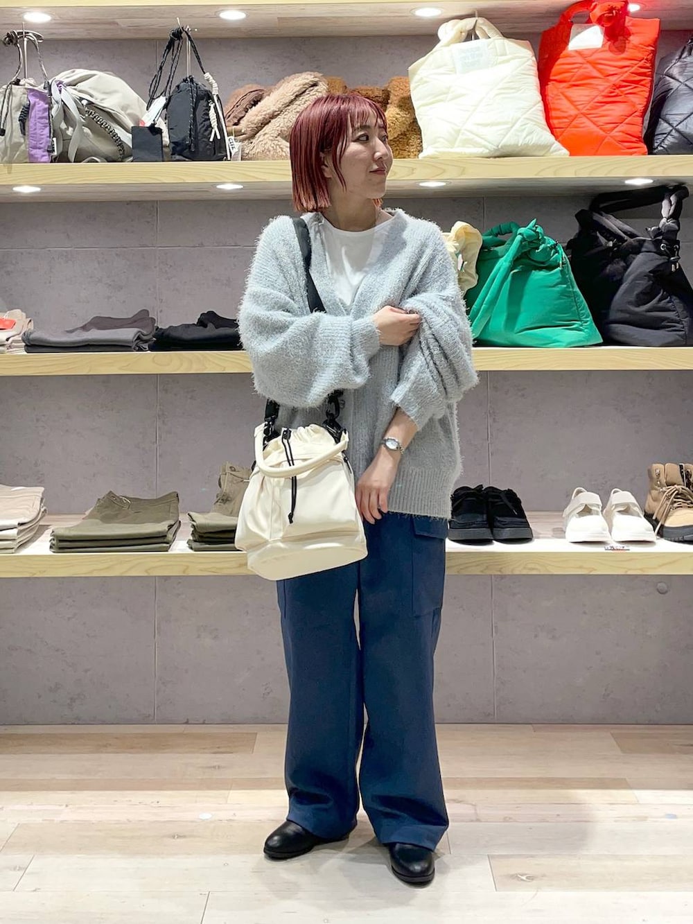 ホワイト系のTシャツ/カットソー、ブラック系のブーツ、グレー系のニット/セーターを着用したレディースの冬コーディネートの2枚目の写真