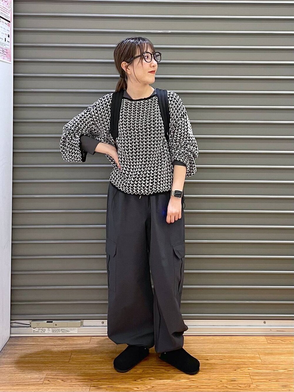 ブラック系のニット/セーター、グレー系のカーゴパンツ、ブラック系のバックパック/リュックを着用したレディースの春コーディネートの3枚目の写真