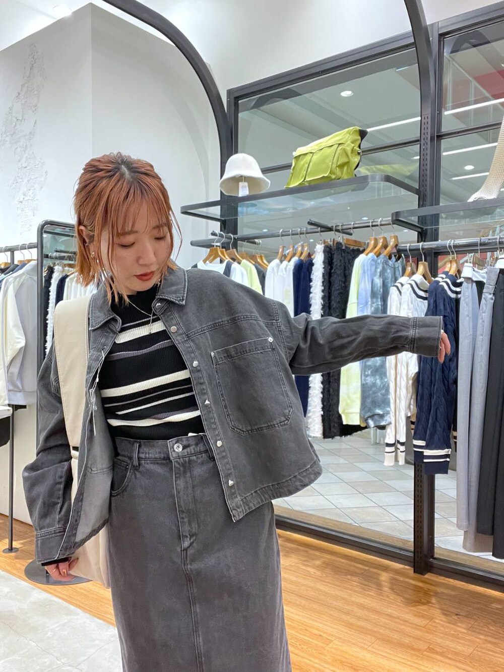 ホワイト系のショルダーバッグ、グレー系のシャツ/ブラウス、ブラック系のニット/セーターを着用したレディースの春コーディネートの4枚目の写真