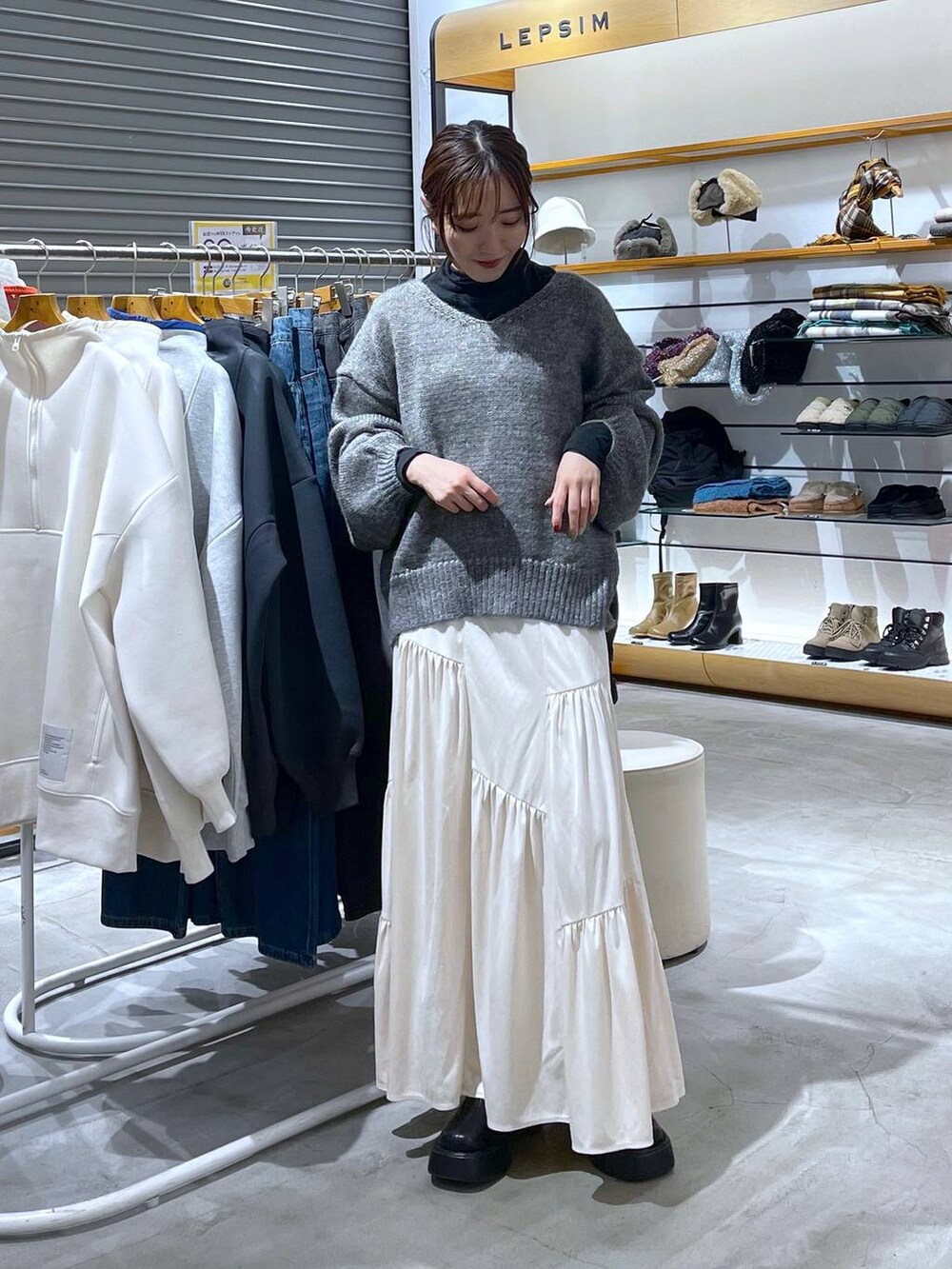 ブラック系のブーツ、グレー系のニット/セーター、ブラック系のTシャツ/カットソーを着用したレディースの秋コーディネートの3枚目の写真