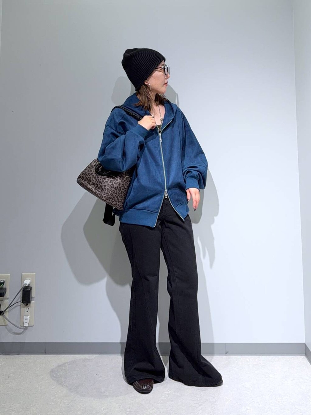 ブルー系のパーカー、ブラウン系のローファー、ブラック系のデニムパンツを着用したレディースの秋コーディネートの2枚目の写真