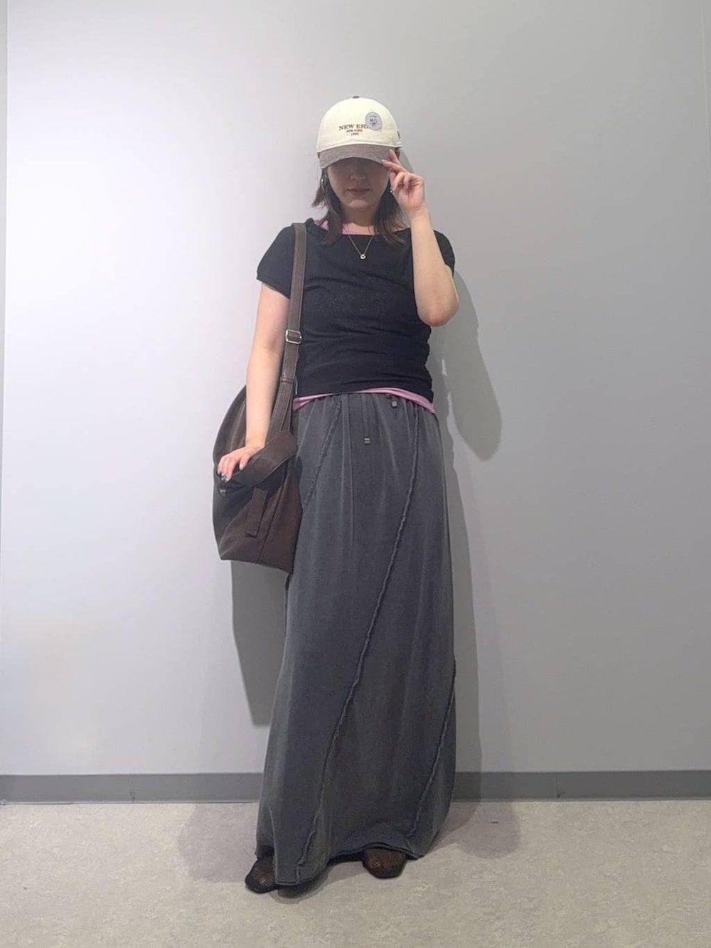 ブラック系のスカート、ブラック系のTシャツ/カットソー、ブラウン系のショルダーバッグを着用したレディースの夏コーディネートの2枚目の写真
