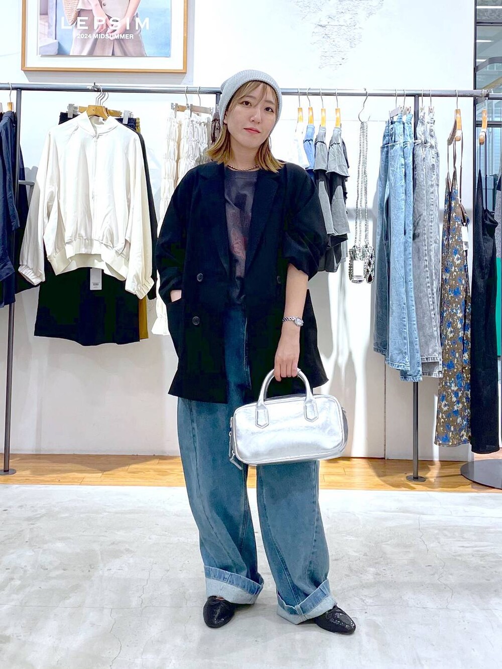 ブルー系のデニムパンツ、シルバー系のボストンバッグ、ブラック系のバレエシューズを着用したレディースの秋コーディネートの2枚目の写真