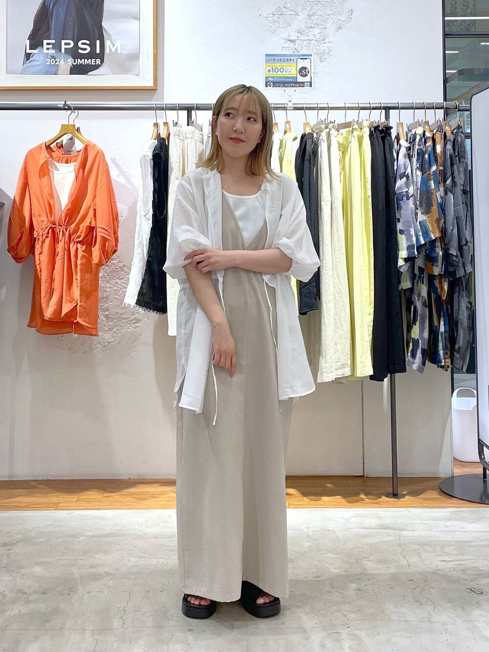 ブラック系のワンピース、ブラック系のサンダル、ホワイト系のシャツ/ブラウスを着用したレディースの夏コーディネートの2枚目の写真