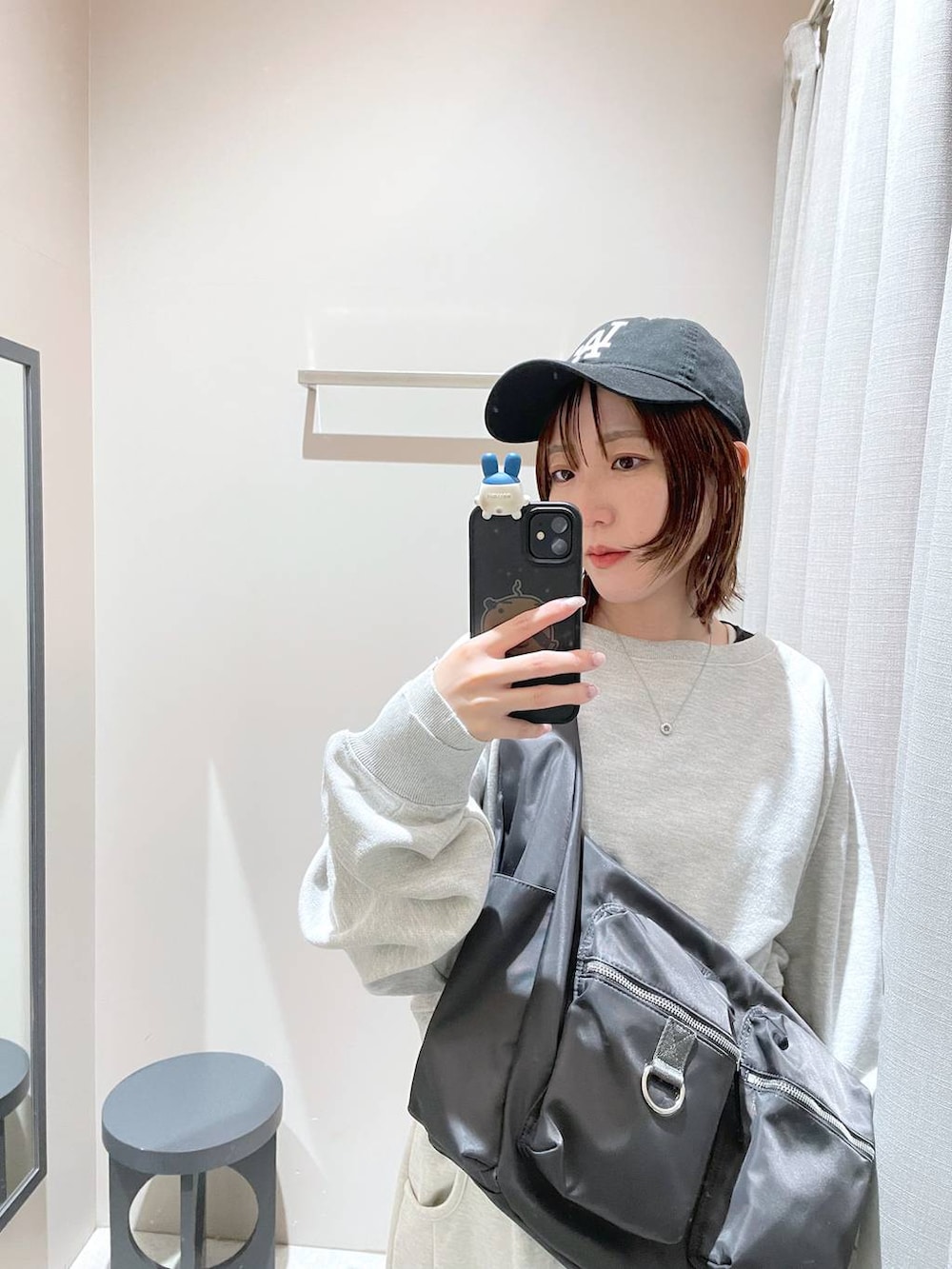 グレー系のショルダーバッグ、グレー系のスウェット、ベージュ系のスウェットパンツを着用したレディースの冬コーディネートの6枚目の写真