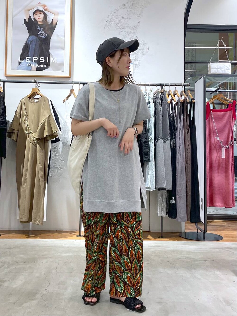 グリーン系のその他パンツ、グレー系のチュニック、ホワイト系のトートバッグを着用したレディースの夏コーディネートの2枚目の写真