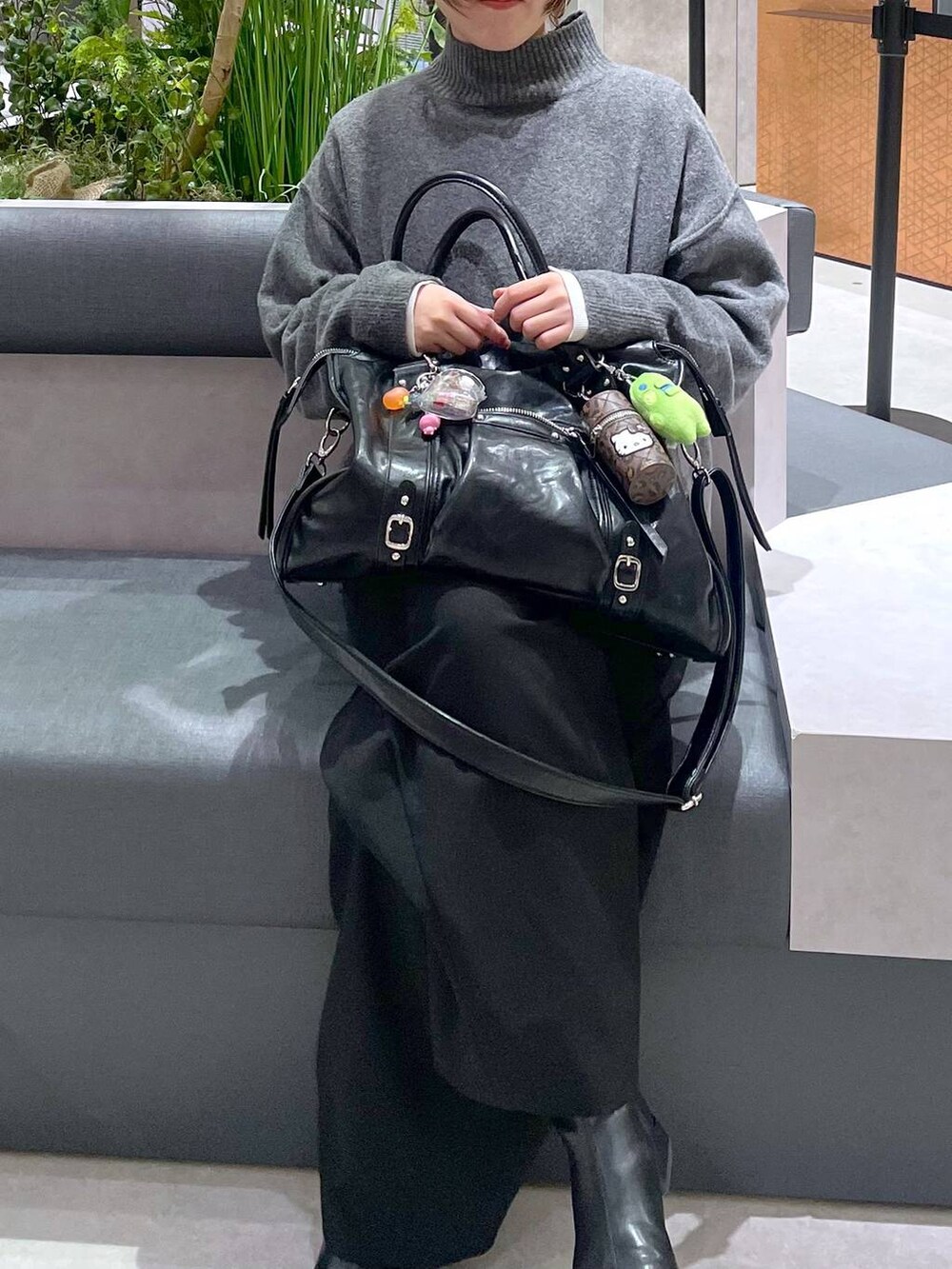 ホワイト系のTシャツ/カットソー、ブラック系のスラックス、グレー系のニット/セーターを着用したレディースの冬コーディネートの2枚目の写真