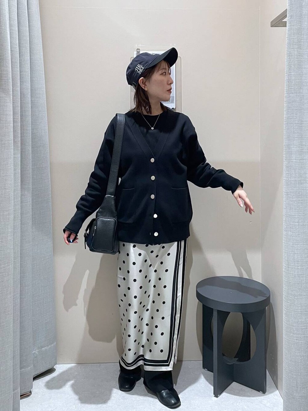 ブラック系のカーディガン/ボレロ、ブラック系のショルダーバッグ、ベージュ系のバンダナ/スカーフを着用したレディースの冬コーディネートの2枚目の写真