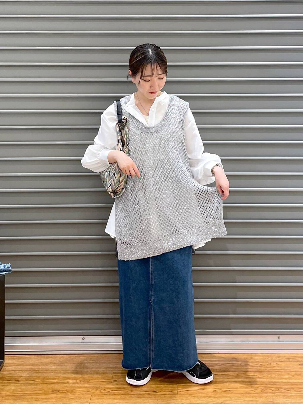 ホワイト系のシャツ/ブラウス、ブラック系のサンダル、ブルー系のスカートを着用したレディースの春コーディネートの2枚目の写真