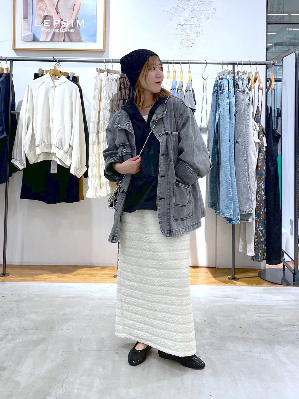 シルバー系のショルダーバッグ、グレー系のデニムジャケット、ブラック系のバレエシューズを着用したレディースの秋コーディネートの2枚目の写真