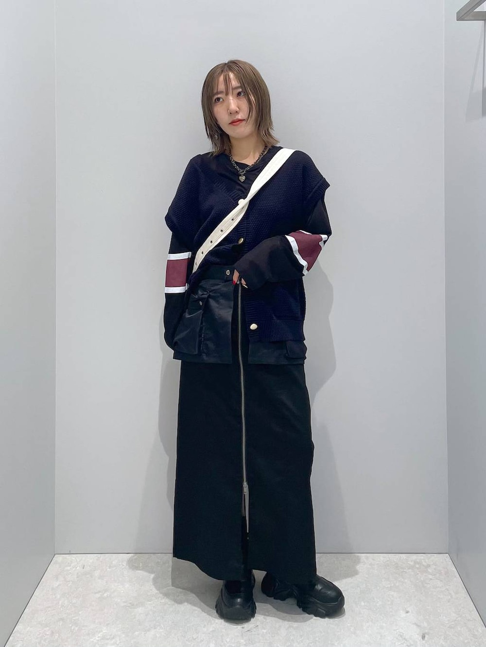 ホワイト系のショルダーバッグ、ブラック系のTシャツ/カットソー、ブラック系のスカートを着用したレディースの秋コーディネートの4枚目の写真