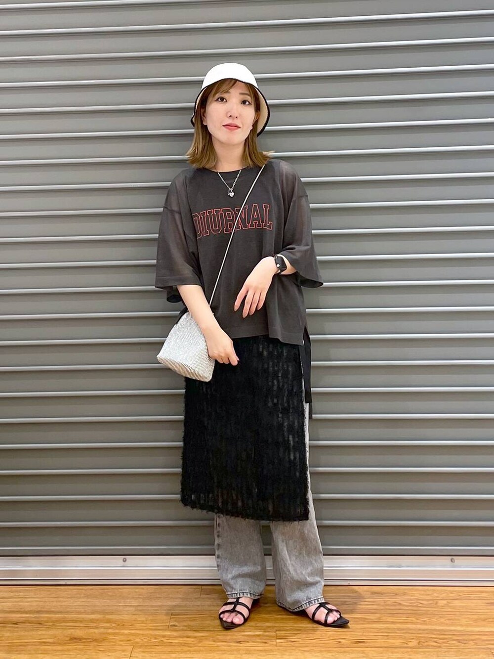 シルバー系のショルダーバッグ、グレー系のその他トップス、ブラック系のスカートを着用したレディースの夏コーディネートの2枚目の写真