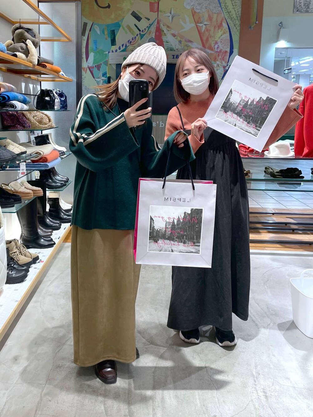 オレンジ系のニット/セーター、ベージュ系のスカート、グレー系のワンピースを着用したレディースの冬コーディネートの3枚目の写真