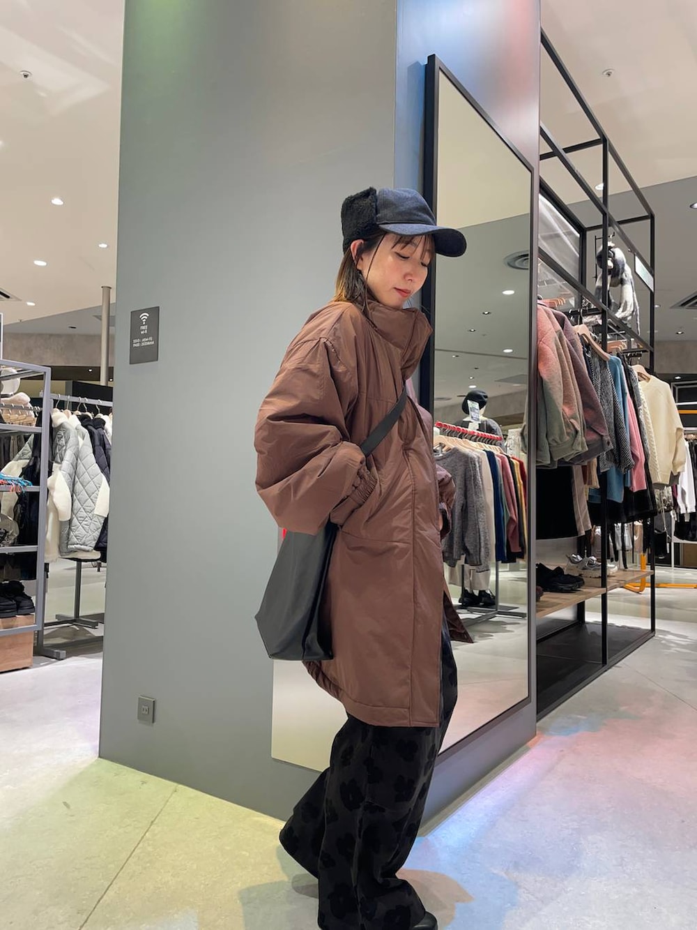 ブラック系のショルダーバッグ、ブラウン系のブルゾン、グレー系のその他パンツを着用したレディースの秋コーディネートの2枚目の写真