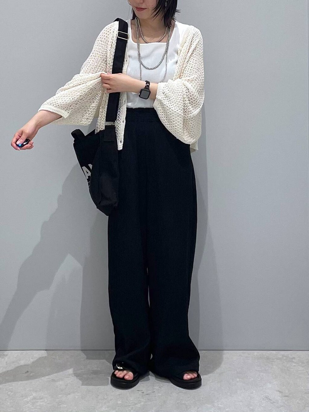 ブラック系のその他パンツ、ホワイト系のタンクトップ、ブラック系のサンダルを着用したレディースの春コーディネートの3枚目の写真