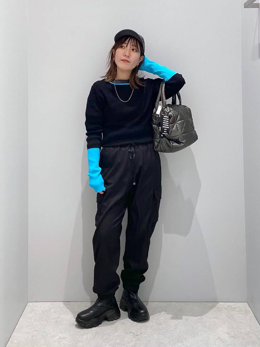 ブラック系のブルゾン、ブラック系のトートバッグ、ブラック系のカーゴパンツを着用したレディースの冬コーディネートの7枚目の写真