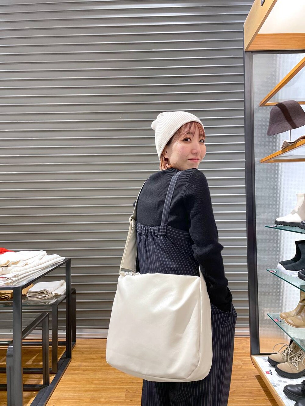 ブラック系のニット/セーター、ホワイト系のショルダーバッグ、ブルー系のその他パンツを着用したレディースの冬コーディネートの4枚目の写真