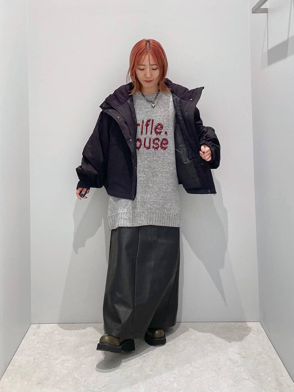 ブラック系のその他アウター、グリーン系のブーツ、グレー系のニット/セーターを着用したレディースの秋コーディネートの2枚目の写真