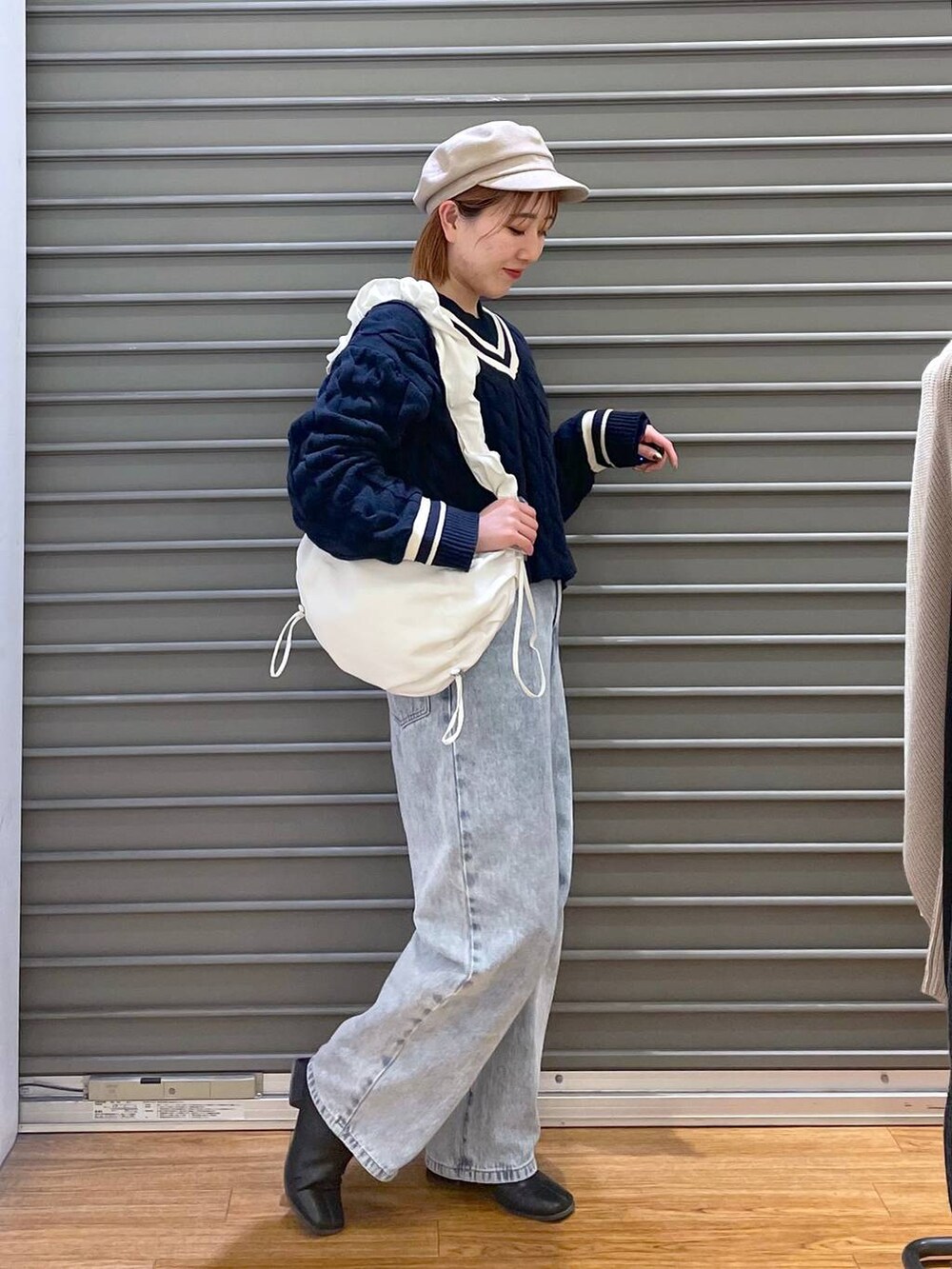 ブルー系のデニムパンツ、ホワイト系のショルダーバッグ、ブルー系のTシャツ/カットソーを着用したレディースの春コーディネートの2枚目の写真