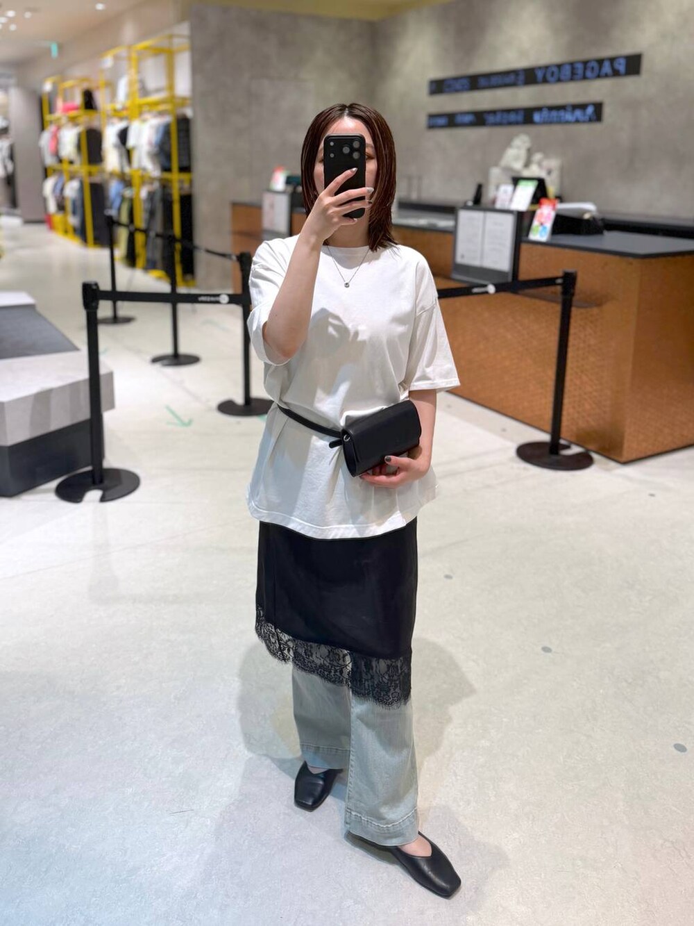 ブラック系のボディバッグ/ウエストポーチ、ホワイト系のTシャツ/カットソー、ブラック系のスカートを着用したレディースの夏コーディネートの2枚目の写真