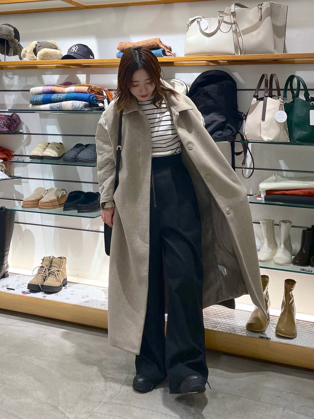 ホワイト系のニット/セーター、ブラック系のブーツ、ブラック系のその他パンツを着用したレディースの冬コーディネートの2枚目の写真