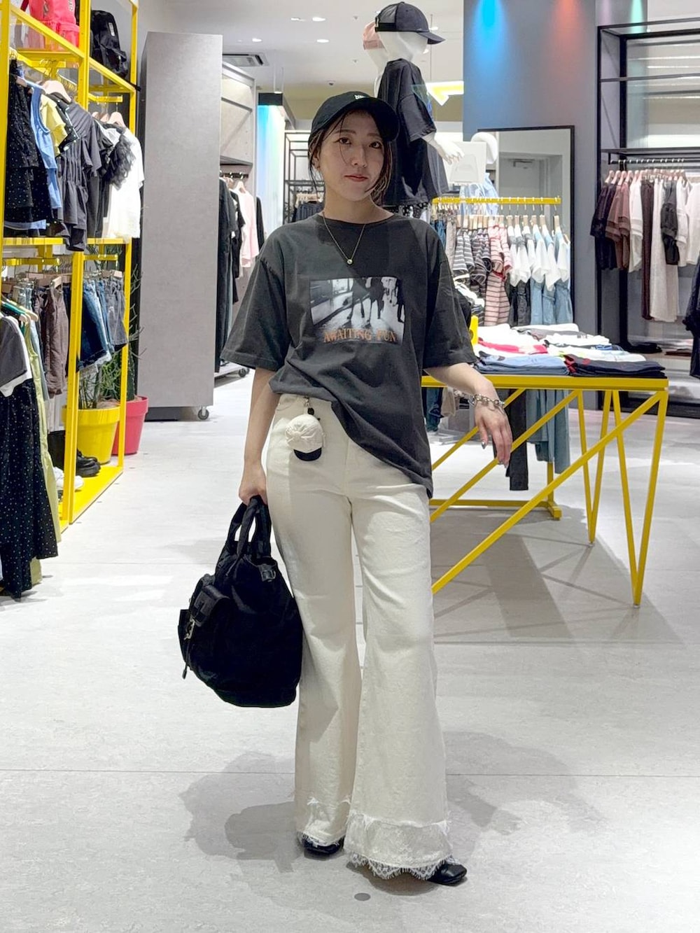 ブラック系のトートバッグ、ホワイト系のデニムパンツ、ホワイト系のTシャツ/カットソーを着用したレディースの夏コーディネートの2枚目の写真