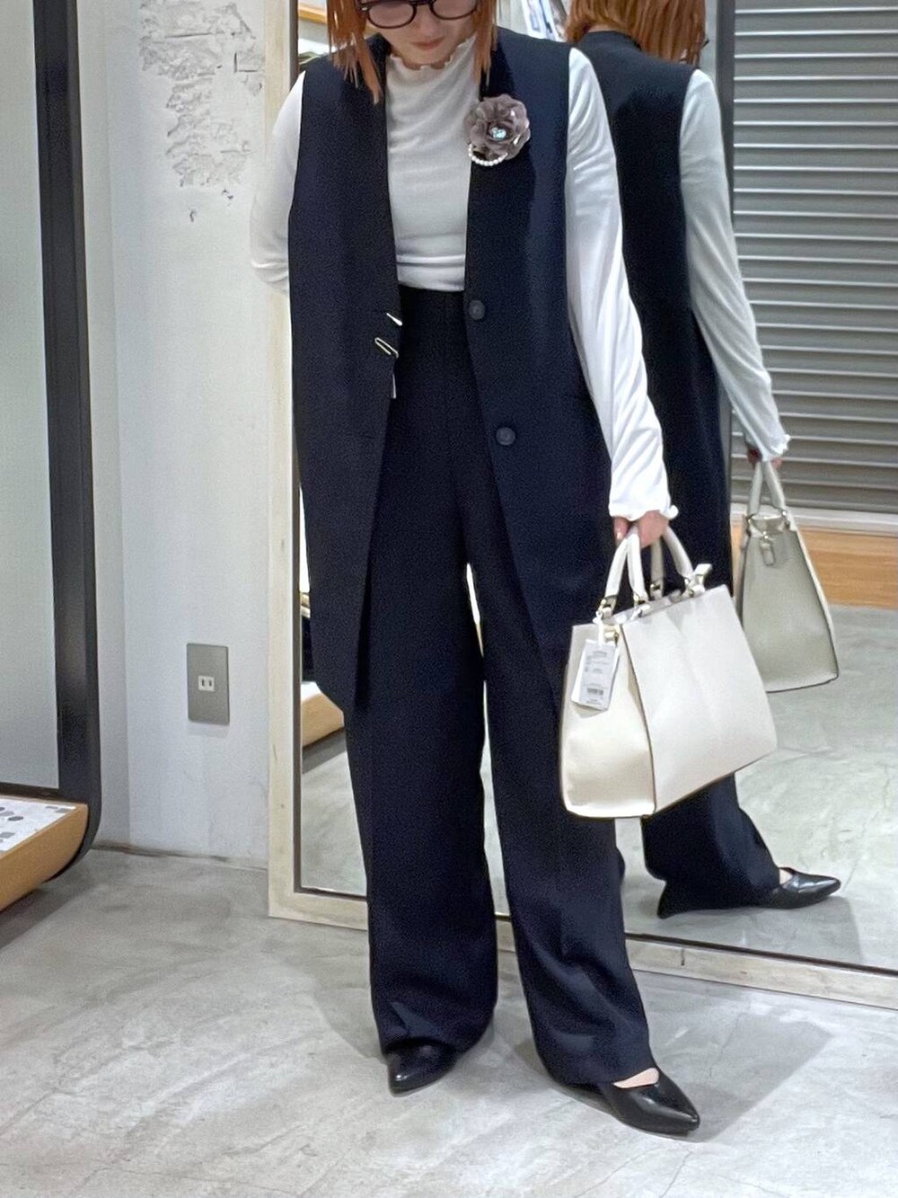 ホワイト系のTシャツ/カットソー、ホワイト系のショルダーバッグ、ブラック系のパンプスを着用したレディースの冬コーディネートの3枚目の写真