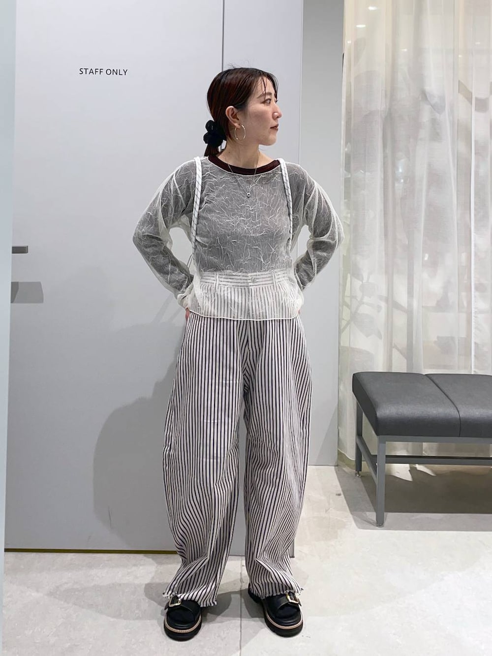 ホワイト系のデニムパンツ、ブラック系のサンダル、ベージュ系のバックパック/リュックを着用したレディースの春コーディネートの2枚目の写真