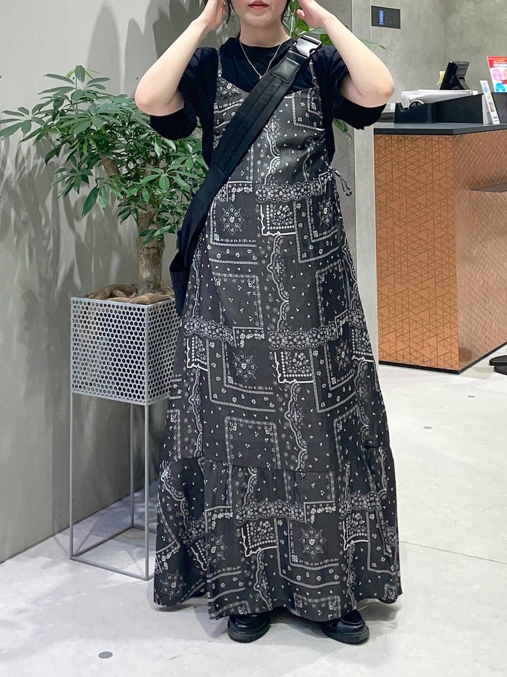 ブラック系のショルダーバッグ、ブラック系のワンピース、ブラック系のTシャツ/カットソーを着用したレディースの春コーディネートの2枚目の写真