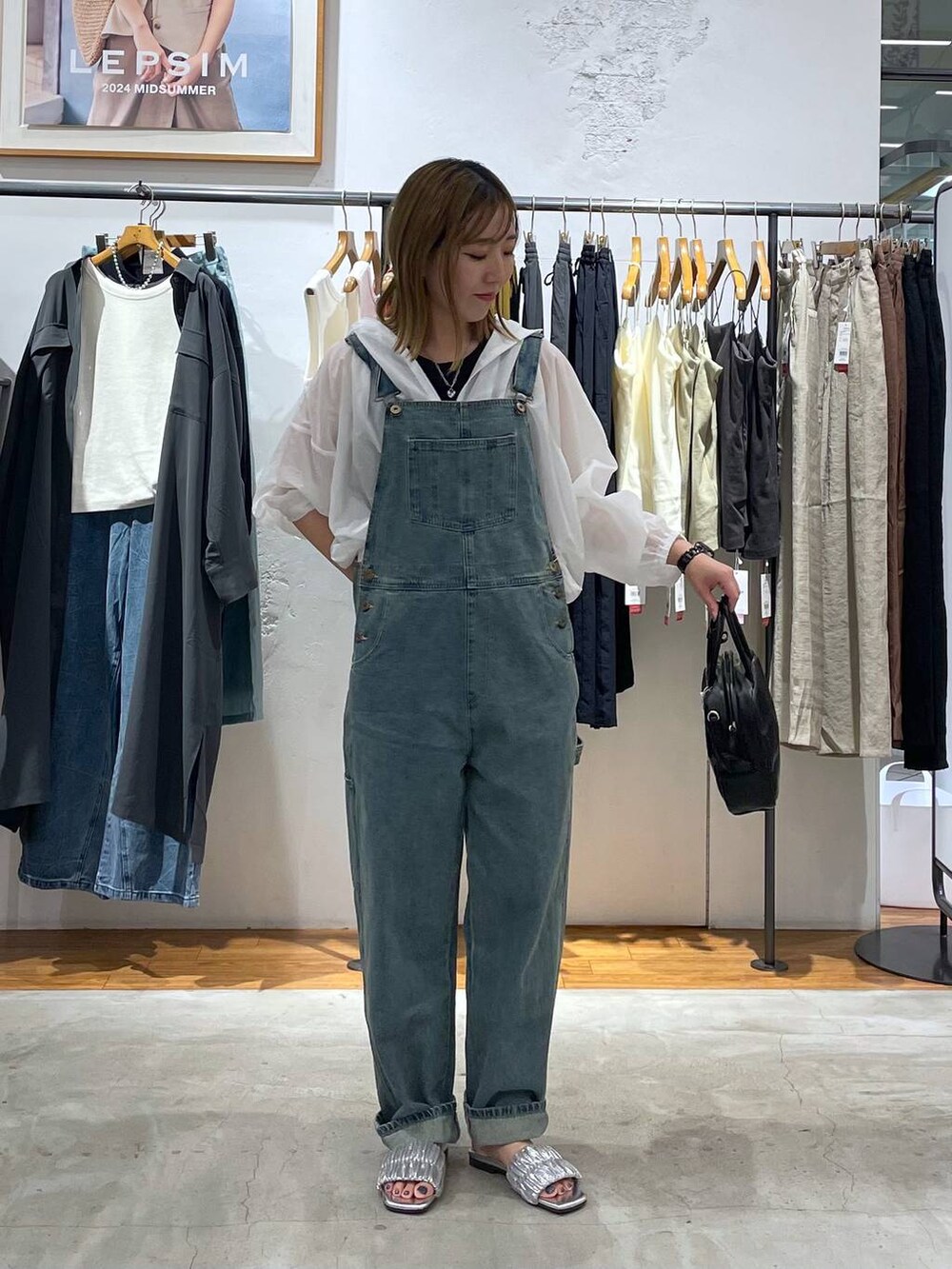 ブラック系のタンクトップ、ブルー系のサロペット/オーバーオール、シルバー系のサンダルを着用したレディースの秋コーディネートの2枚目の写真