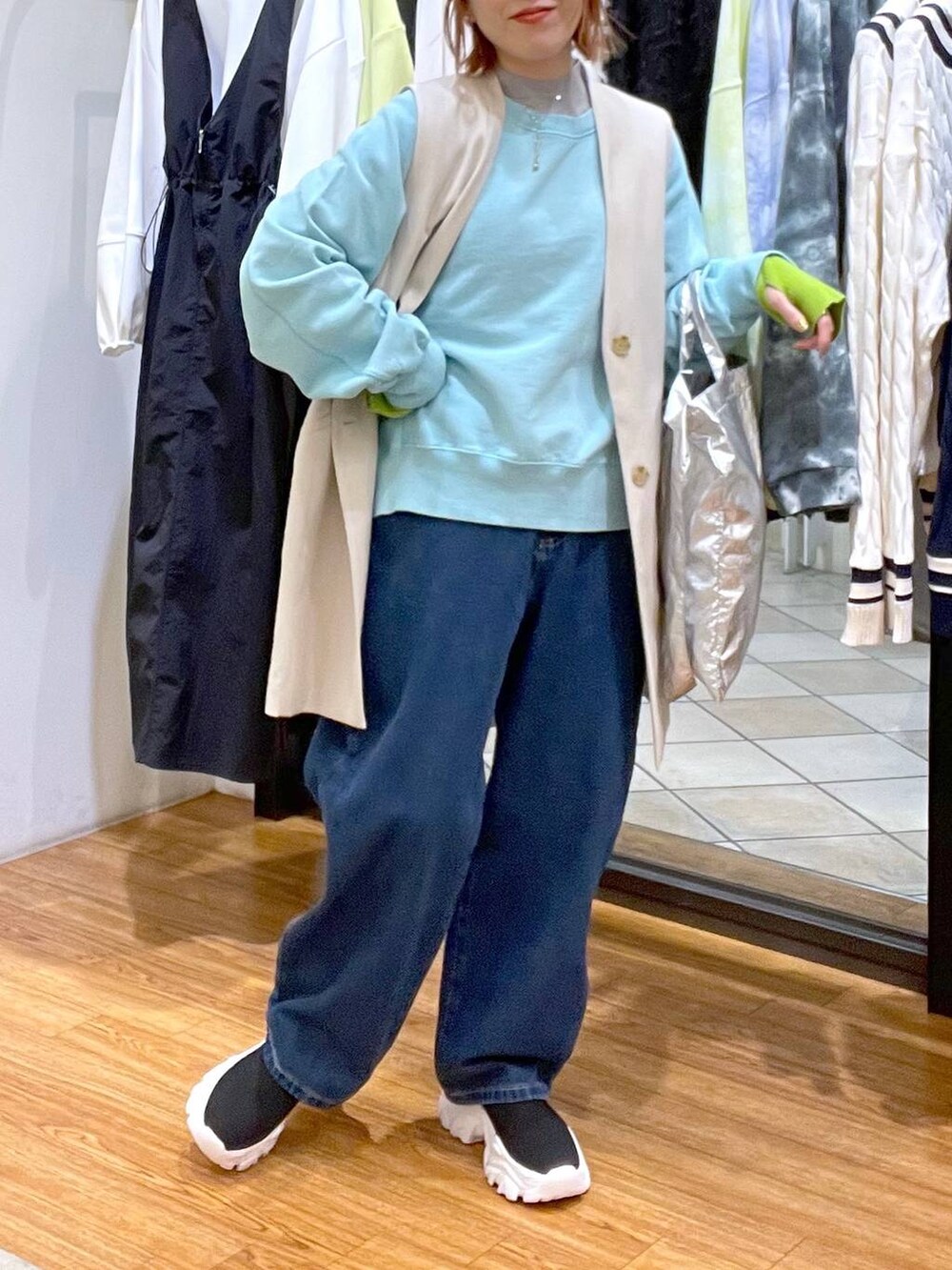 ブルー系のデニムパンツ、ブルー系のTシャツ/カットソー、シルバー系のトートバッグを着用したレディースの春コーディネートの4枚目の写真