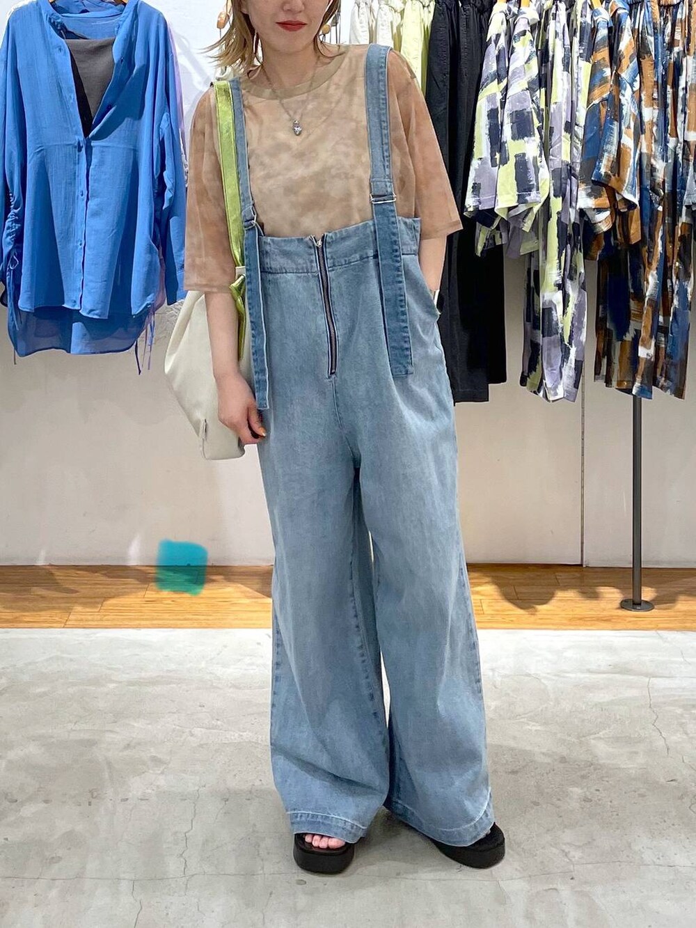 ブラウン系のTシャツ/カットソー、ブルー系のデニムパンツ、ホワイト系のショルダーバッグを着用したレディースの春コーディネートの3枚目の写真