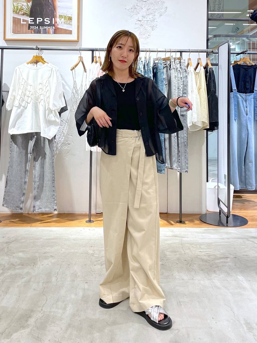 シルバー系のサンダル、ブラック系のショルダーバッグ、ホワイト系のその他パンツを着用したレディースの夏コーディネートの2枚目の写真