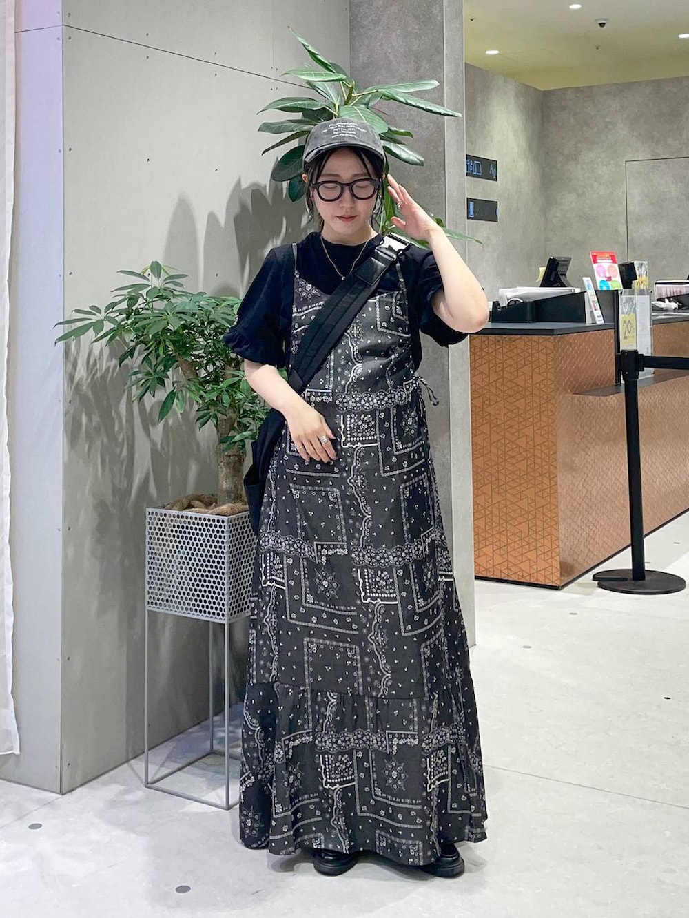ブラック系のショルダーバッグ、ブラック系のワンピース、ブラック系のTシャツ/カットソーを着用したレディースの春コーディネートの3枚目の写真